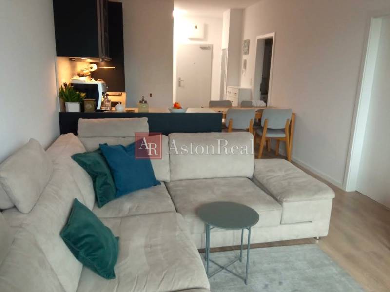 VÝMENA! Nový 2+kk s park. miestom a lodžiou za 3+1, Rača, Bratislava - Obývačka s pohovkou a stolíkom v 2-izbovom byte s podlahou s dreveným dekorom.