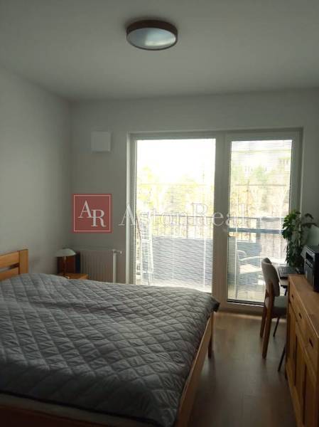 VÝMENA! Nový 2+kk s park. miestom a lodžiou za 3+1, Rača, Bratislava - Spálňa v 2-izbovom byte s posteľou a balkónom, podlaha s dreveným dekorom.