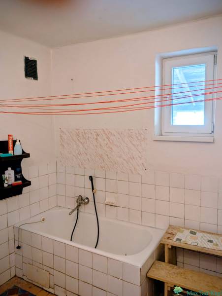 Rodinný dom s veľkou terasou a garážou v  Lastovciach za  73 500 € - Kúpeľňa v rodinnom dome s vaňou, poličkou a bielymi kachličkami.