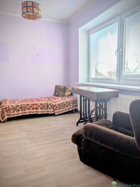 Rodinný dom s veľkou terasou a garážou v  Lastovciach za  73 500 € - Izba v rodinnom dome s rozkladacím gaučom a kreslom, podlaha s dreveným dekorom.