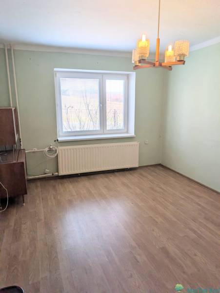 Rodinný dom s veľkou terasou a garážou v  Lastovciach za  73 500 € - Izba v Rodinnom dome s podlahou s dreveným dekorom a oknom s radiátorom.