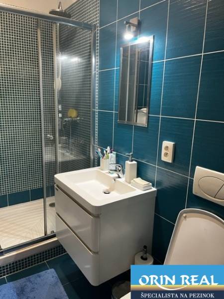 ÚTULNÝ 2 IZBOVÝ BYT - SILVANIUM  - Kúpeľňa v 2-izbovom byte s moderným umývadlom a sprchovacím kútom.