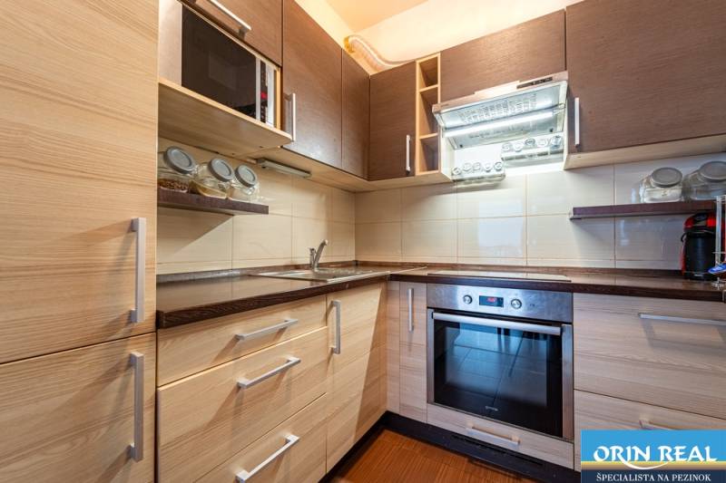 SVETLÝ ZARIADENÝ 2-IZBOVÝ BYT S BALKÓNOM - LA VITA  - Kuchyňa v 2-izbovom byte s podlahou s dreveným dekorom a vstavanými spotrebičmi.