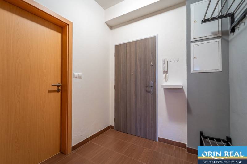 SVETLÝ ZARIADENÝ 2-IZBOVÝ BYT S BALKÓNOM - LA VITA  - Vstupná chodba 2-izbového bytu s podlahou s dreveným dekorom a bielymi stenami.