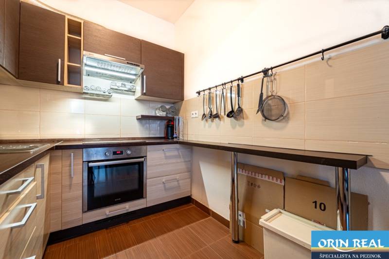 SVETLÝ ZARIADENÝ 2-IZBOVÝ BYT S BALKÓNOM - LA VITA  - Kuchyňa v 2-izbovom byte s podlahou s dreveným dekorom a praktickými úložnými priestormi.