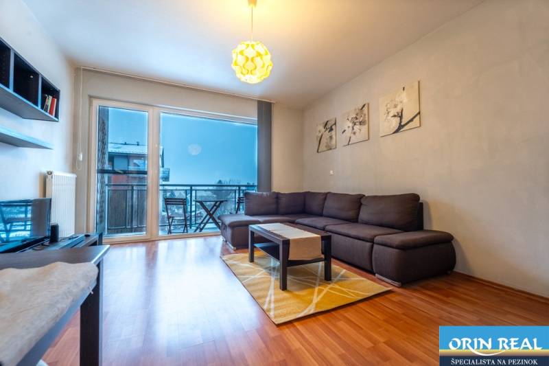 SVETLÝ ZARIADENÝ 2-IZBOVÝ BYT S BALKÓNOM - LA VITA  - Obývacia izba v 2-izbovom byte s podlahou s dreveným dekorom a veľkými oknami.