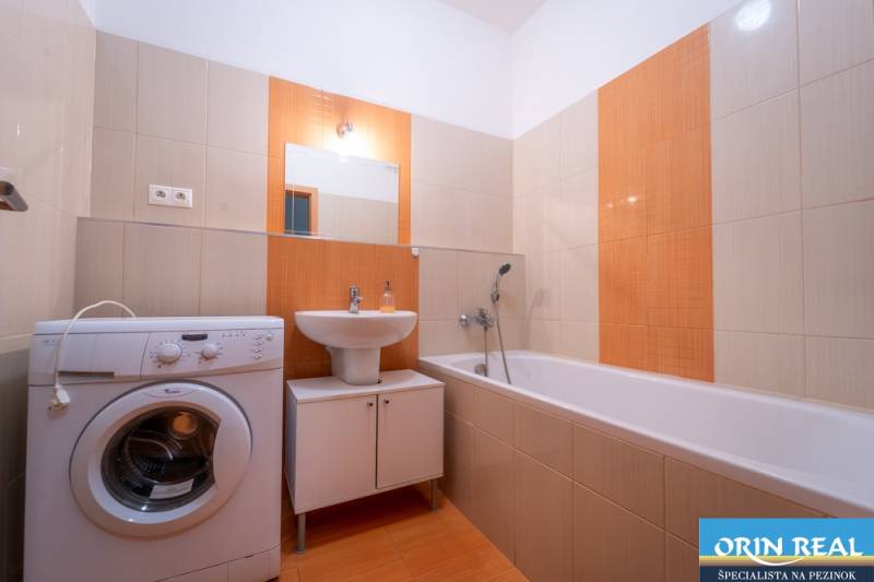 SVETLÝ ZARIADENÝ 2-IZBOVÝ BYT S BALKÓNOM - LA VITA  - Kúpeľňa v 2-izbovom byte s vaňou, umývadlom a práčkou, svetlé obloženie.