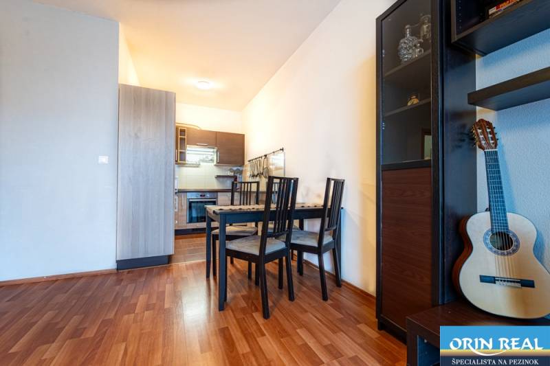 SVETLÝ ZARIADENÝ 2-IZBOVÝ BYT S BALKÓNOM - LA VITA  - Jedálenský kút s kuchyňou v 2-izbovom byte, podlaha s dreveným dekorom, gitara.