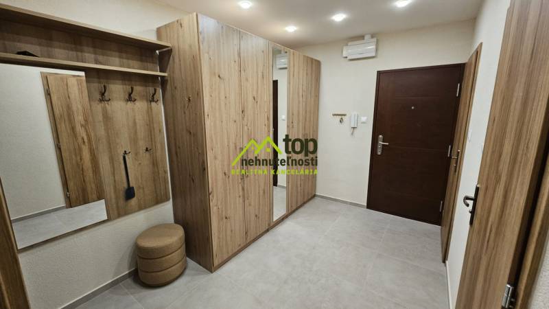 Prenájom 2 izbový byt v Topoľčanoch, sídlisko JUH - Chodba v 2-izbovom byte s nábytkom s dreveným dekorom a vstavaným zrkadlom.