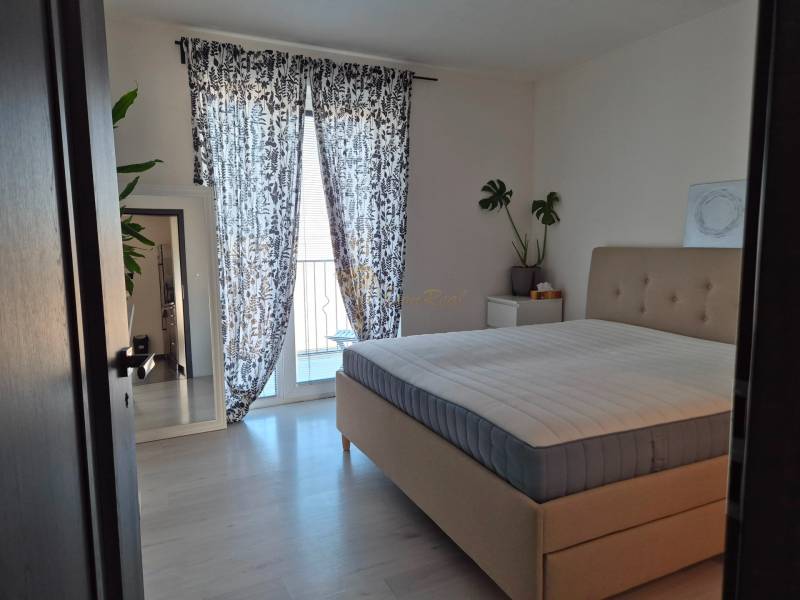 3-izb. byt v obci Blatná na Ostrove, balkón, lodžia, novostavba - Spálňa s veľkou posteľou, rastlinami, zrkadlom a závesmi v 3-izbovom byte.