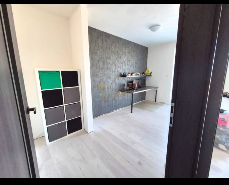 3-izb. byt v obci Blatná na Ostrove, balkón, lodžia, novostavba - Izba v 3-izbovom byte s podlahou s dreveným dekorom a dekoratívnou stenou.