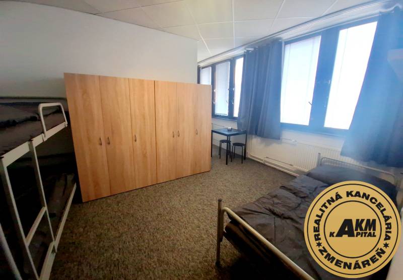 Ubytovanie pre zamestnancov, 64 m2, Tulská ul., Zvolen - Západ - Nábytok v interiéri budovy s posteľami, skriňou a stolom na koberci.