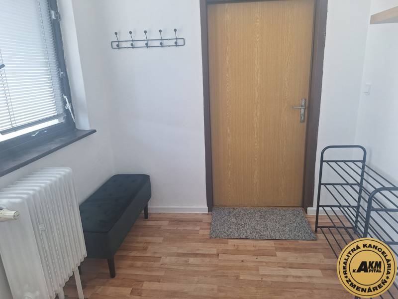 Ubytovanie pre zamestnancov, 64 m2, Tulská ul., Zvolen - Západ - V Budove s podlahou s dreveným dekorom je lavička, radiátor a vešiak na stene.