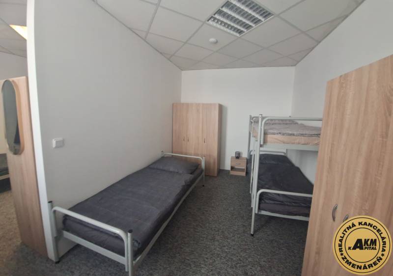 Ubytovanie pre zamestnancov, 64 m2, Tulská ul., Zvolen - Západ - Interiér budovy s posteľami a skriňami, podlaha s dreveným dekorom.