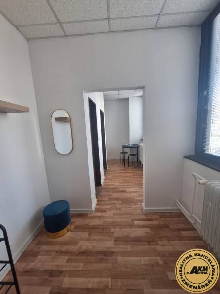 Ubytovanie pre zamestnancov, 64 m2, Tulská ul., Zvolen - Západ - Interiér budovy s podlahou s dreveným dekorom, stoličky, zrkadlo, biely strop.