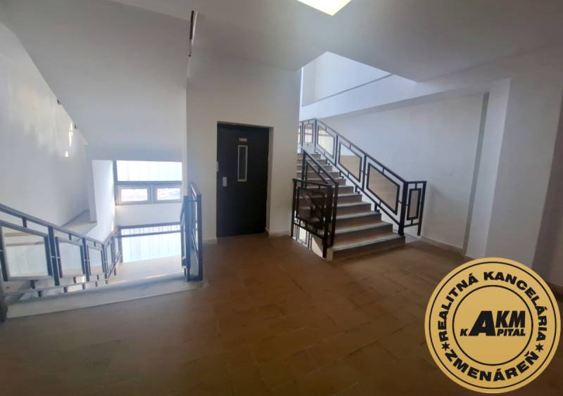 Ubytovanie pre zamestnancov, 64 m2, Tulská ul., Zvolen - Západ - Interiér budovy so schodiskom a vyťahom, podlaha s dreveným dekorom.