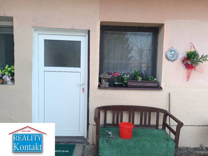 Na prenájom 1-izbový byt - Nové Zámky - Vstup do 1-izbového bytu s lavičkou a kvetinovou výzdobou.