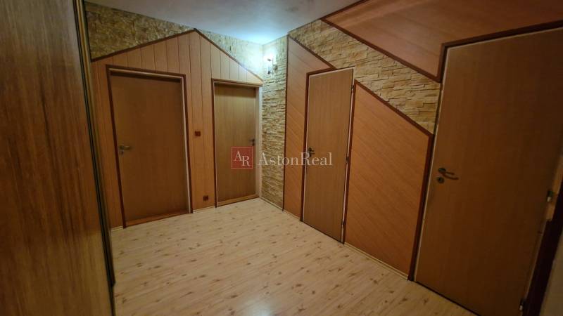 EXKLUZÍVNE-PREDAJ 3-IZBOVÝ BYT POPRAD, juh-bl.Slnečnica 80 m2  2 balk. - Chodba s tromi dverami a podlahou s dreveným dekorom v 3-izbovom byte.