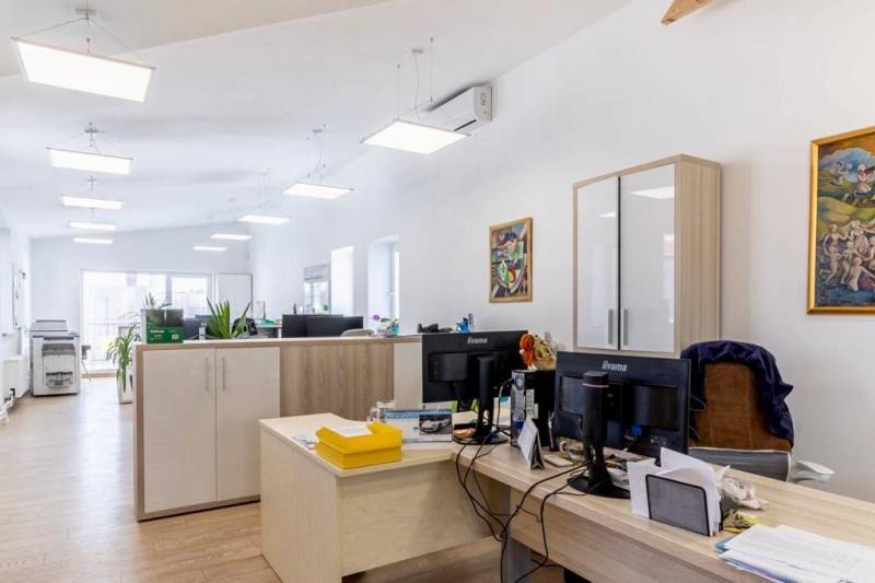 NA PRENÁJOM-Kancelársky priestor-Košice-Staré mesto,Masarykova ul. - Kancelárie s podlahou s dreveným dekorom, pracovnými stolmi a skladovými skrinkami.