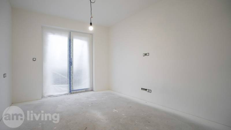 NOVINKA - 2x Novostavba RODINNÝCH DOMOV - Borčice  - Prázdna miestnosť v rodinnom dome so závesnou žiarovkou a zatvorenými dverami na terasu.