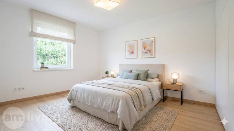 NOVINKA - 2x Novostavba RODINNÝCH DOMOV - Borčice  - Svetlá spálňa s podlahou s dreveným dekorom, posteľ so svetlým prehozom a obrazmi na stene.