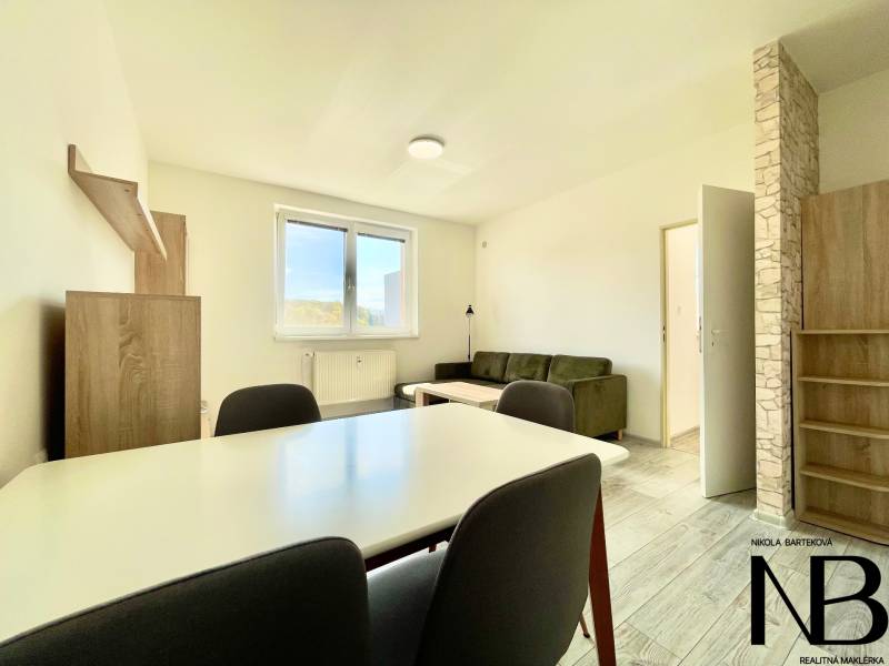 Na prenájom slnečný 2i byt s balkónom, ul. Východná, Trenčín - Obývacia izba v 2-izbovom byte s podlahou s dreveným dekorom, sedačka a jedálenský stôl.