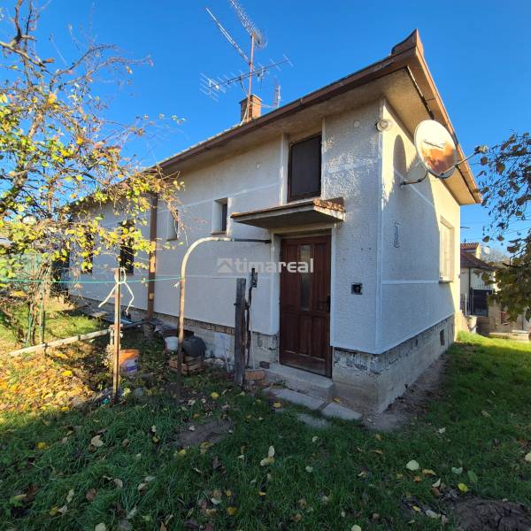 * na predaj 3i rodinný dom, 6á pozemok, Čataj - Rodinný dom v Čataji s bielou fasádou, satelitnou anténou a okolím z listnatých stromov.