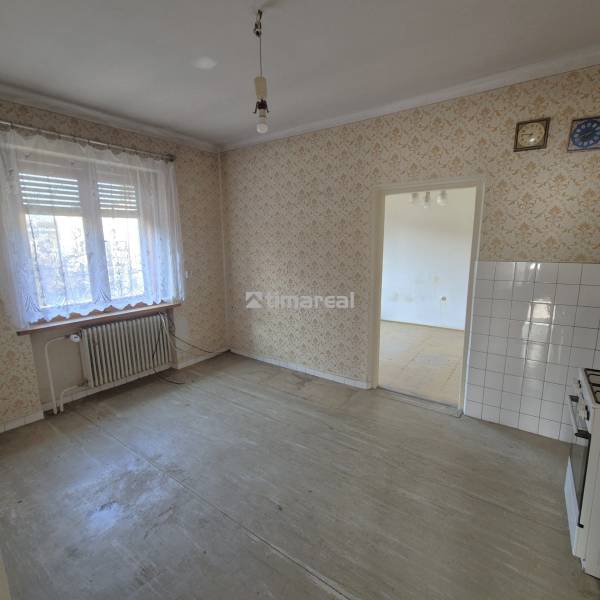 * na predaj 3i rodinný dom, 6á pozemok, Čataj - Kuchyňa v rodinnom dome s vintage tapetou, dlažbou a starým sporákom.