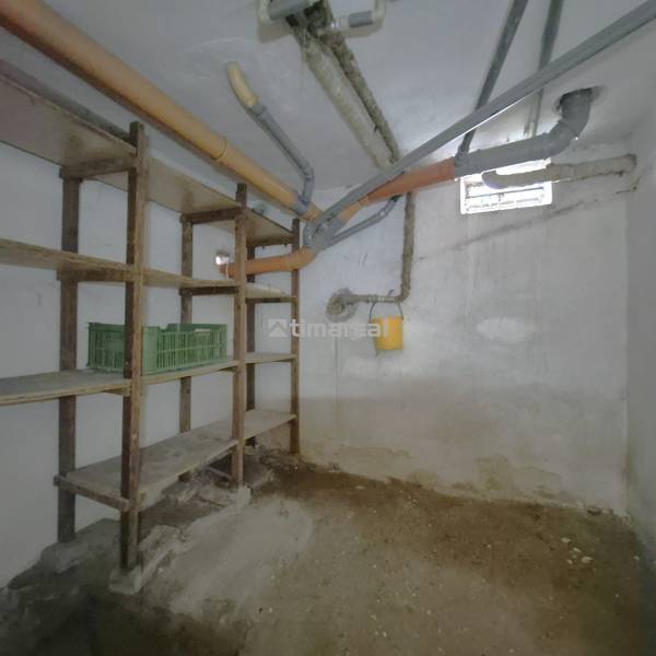 * na predaj 3i rodinný dom, 6á pozemok, Čataj - Suterén v rodinnom dome v Čataji s regálmi a potrubím pod stropom.