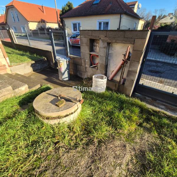 * na predaj 3i rodinný dom, 6á pozemok, Čataj - Pred rodinným domom v Čataji je poklop a trávnatá plocha.