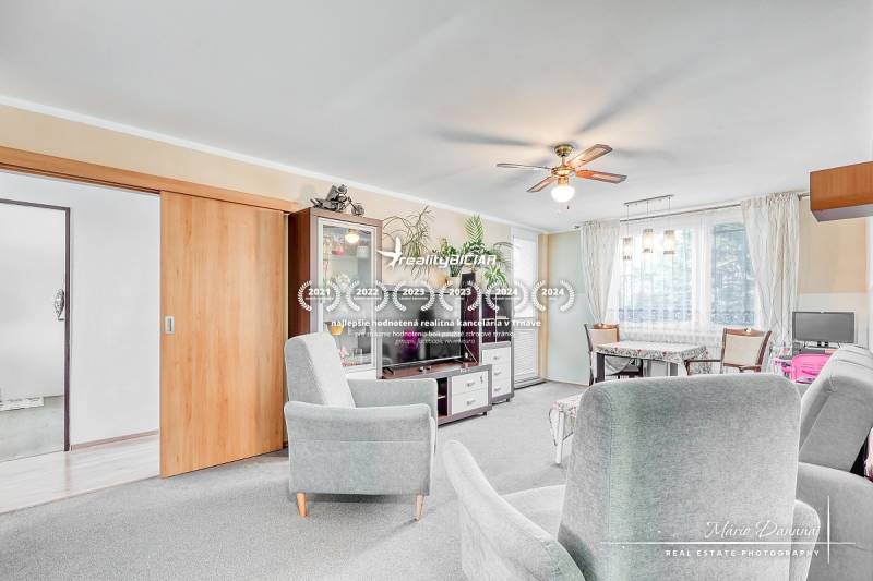 REZERVOVANÉ 4-izbový byt v Trnave na Veternej ulici - Svetlá obývačka so sedačkami v 4-izbovom byte a podlahou s dreveným dekorom.