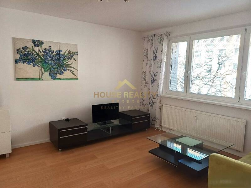 Zariadený 3 izbový byt s lodžiou, Beniakova ulica, BA IV. Karlova Ves - Obývačka s podlahou s dreveným dekorom, v 3-izbovom byte, zahŕňa televíziu a stolík.