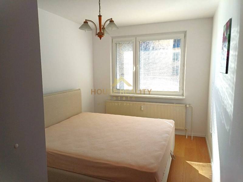 Zariadený 3 izbový byt s lodžiou, Beniakova ulica, BA IV. Karlova Ves - Spálňa v 3-izbovom byte s posteľou a podlahou s dreveným dekorom.