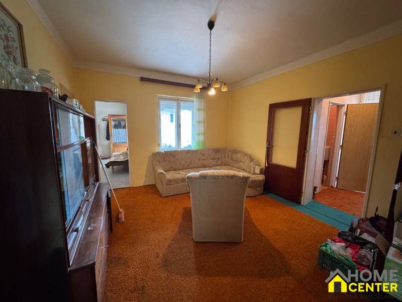 NA PREDAJ!!! Rodinný dom s veľkým pozemkom v obci Vék pri Hurbanove - Obývacia izba rodinného domu so starším nábytkom, pohovkou a kobercom.