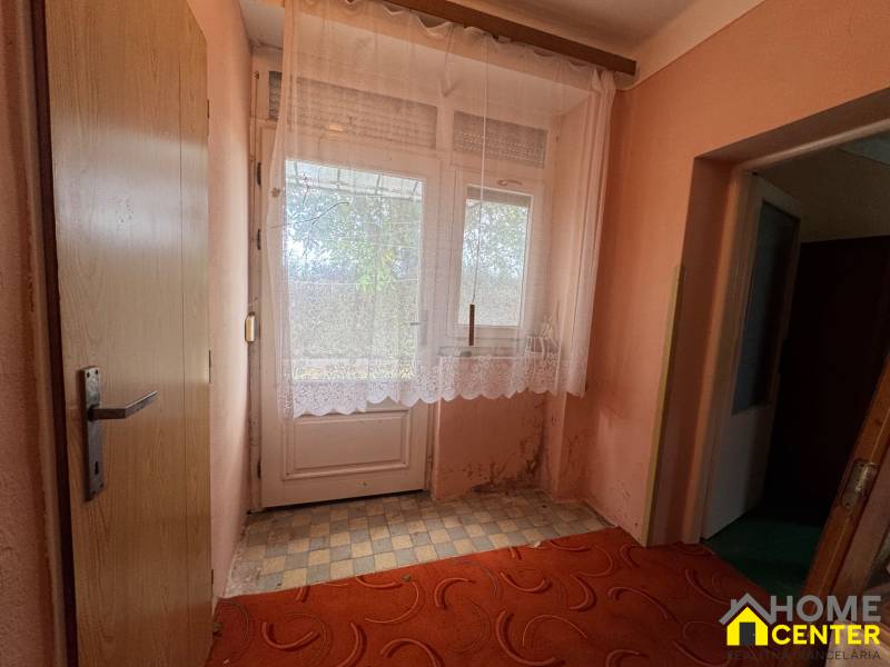 NA PREDAJ!!! Rodinný dom s veľkým pozemkom v obci Vék pri Hurbanove - Interiér rodinného domu s dverami a záclonami na okne, podlaha s károvaným dekorom.