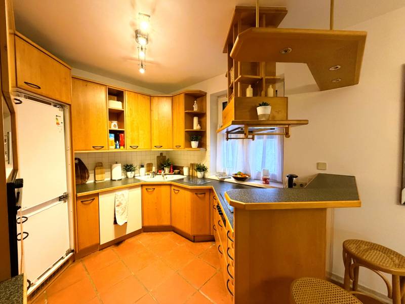 3 izbový byt s balkónom v obľúbenej lokalite Neusiedl am See - Kuchyňa v 3-izbovom byte s drevenými skrinkami a barovým pultom.