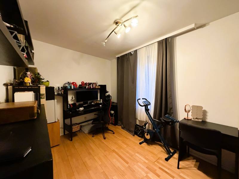 3 izbový byt s balkónom v obľúbenej lokalite Neusiedl am See - Izba s podlahou s dreveným dekorom, písací stôl, počítač, stacionárny bicykel, police.