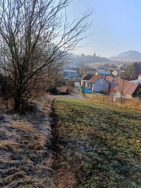 SKLABIŇA -7 km od mesta Martin -stavebný pozemok 1403m2 - Krajina v Sklabini s pozemkami na bývanie, domy a stromy v pozadí.
