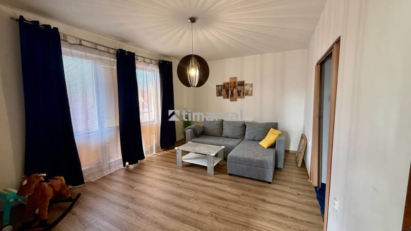 * 7i rodinný dom, veľký 33.5á pozemok, Brestovany - Obývačka v rodinnom dome s pohovkou, konferenčným stolíkom a podlahou s dreveným dekorom.