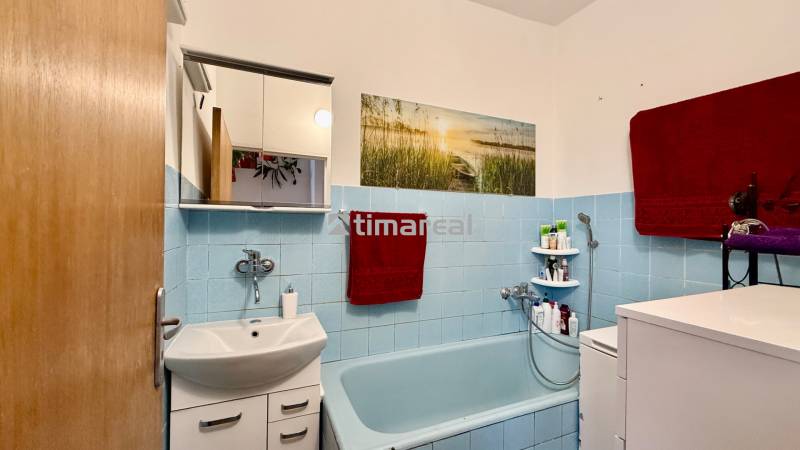 * 7i rodinný dom, veľký 33.5á pozemok, Brestovany - Kúpeľňa v rodinnom dome s modrými obkladačkami, vaňou a skrinkou nad umývadlom.