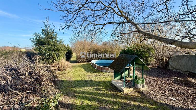 * 7i rodinný dom, veľký 33.5á pozemok, Brestovany - Záhrada pri rodinnom dome na ulici Joža Nižnanského v Brestovanoch s bazénom a dreveným altánkom.