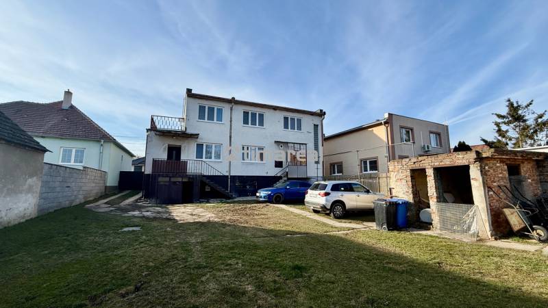 * 7i rodinný dom, veľký 33.5á pozemok, Brestovany - Rodinný dom v Brestovanoch na ulici Joža Nižnanského, s parkoviskom a dvomi autami.