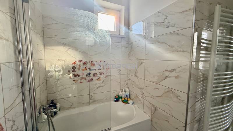 * 7i rodinný dom, veľký 33.5á pozemok, Brestovany - Kúpeľňa v rodinnom dome s vaňou, obklady s mramorovým dekorom a oknom.