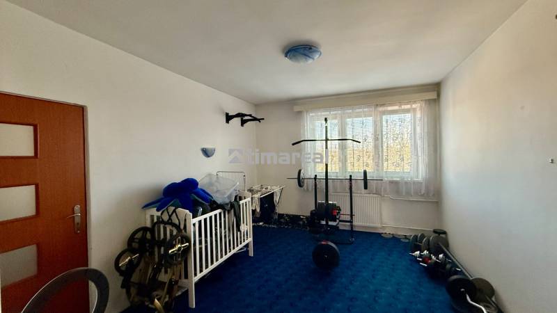 * 7i rodinný dom, veľký 33.5á pozemok, Brestovany - Izba v rodinnom dome s modrým kobercom, detskou postieľkou a cvičebným vybavením.