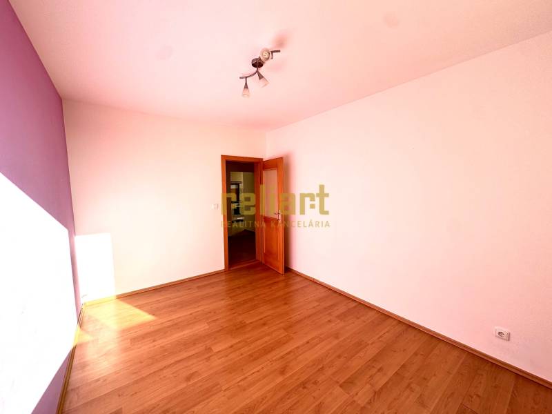 Zrekonštruovaný 3i byt na začiatku Petržalky, električka, les, výhľady - Izba s podlahou s dreveným dekorom v 3-izbovom byte, pastelové steny, stropné svietidlo.