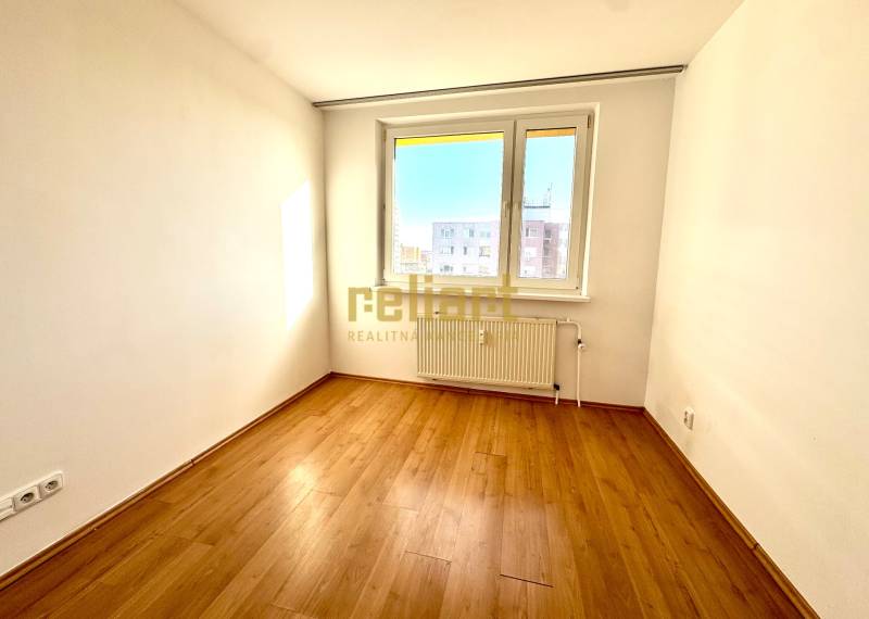 Zrekonštruovaný 3i byt na začiatku Petržalky, električka, les, výhľady - Izba v 3-izbovom byte s podlahou s dreveným dekorom a veľkým oknom.