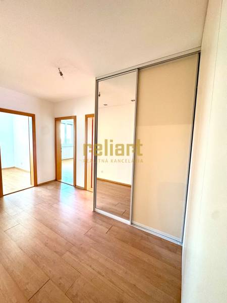 Zrekonštruovaný 3i byt na začiatku Petržalky, električka, les, výhľady - Izba s podlahou s dreveným dekorom a zrkadlovou vstavanou skriňou v 3-izbovom byte.