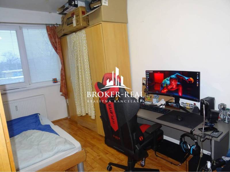 1 - izbový byt Košice, Popradská - Pracovný kútik s počítačom, lôžkom a podlahou s dreveným dekorom v 1-izbovom byte.