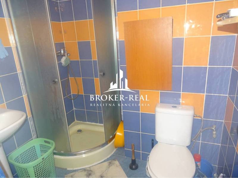1 - izbový byt Košice, Popradská - Kúpeľňa v 1-izbovom byte s farebnými obkladačkami, sprchovacím kútom a toaletou.