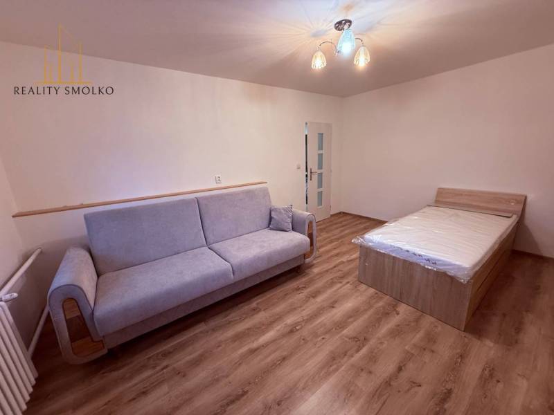 EXKLUZÍVNE: Štýlové bývanie v tichej lokalite Kanaša – po kompletnej r - Izba v rodinnom dome s pohovkou, posteľou a podlahou s dreveným dekorom.